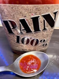 Pain 100% Hot Sauce on a spoon